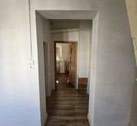 EXKLUZÍVNE NA PREDAJ 2-izbový rodinný dom v širšom centre Nitry s pote - Obývacia izba v rodinnom dome s pohovkou a podlahou s dreveným dekorom.