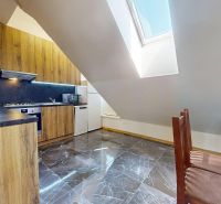 Prémiový podkrovný mezonet v centre Michaloviec | 109,3 m² |  - Kuchyňa v 4-izbovom byte s dreveným dekorom a svetlou strešnou oknov v podkroví.
