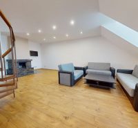Prémiový podkrovný mezonet v centre Michaloviec | 109,3 m² |  - Schodisko v obývačke so sedacou súpravou a kozubom v 4-izbovom byte.