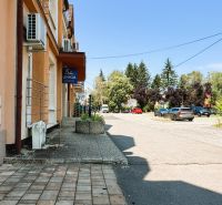 Prémiový podkrovný mezonet v centre Michaloviec | 109,3 m² |  - Ulica Jaroslawská v Michalovciach so zaparkovanými autami a budovou na predaj.
