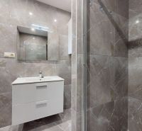 Prémiový podkrovný mezonet v centre Michaloviec | 109,3 m² |  - Kúpeľňa v 4-izbovom byte s obkladmi a sprchovým kútom, elegantná biela skrinka.
