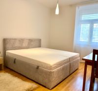 Na prenájom 2 izbový byt, 65 m2, Bratislava, centrum, Vajanského nábr. - Spálňa v 2-izbovom byte s posteľou, nočným stolíkom a drevenou podlahou.