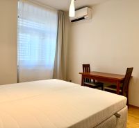 Na prenájom 2 izbový byt, 65 m2, Bratislava, centrum, Vajanského nábr. - Spálňa v 2-izbovom byte s posteľou, stolom a klimatizáciou.