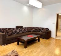 Na prenájom 2 izbový byt, 65 m2, Bratislava, centrum, Vajanského nábr. - Obývačka so sedačkou a stolíkom v 2-izbovom byte s drevenou podlahou.