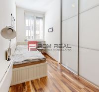 PREDAJ luxusného 3 izbového bytu STARÉ MESTO Bratislava - Spálňa v 3-izbovom byte s posteľou a skriňou, podlaha s dreveným dekorom.