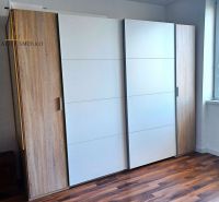 Garsónka po kompletnej rekonštrukcii v širšom centre mesta - Rekreačný apartmán obsahuje bielu vstavanú skriňu s dvoma drevenými dverami a podlahou s dreveným dekorom.