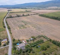 PREDAJ, Stavebný pozemok Sečovce - časť Albinov, intravilan  - Krajina v Sečovciach s rozľahlými pozemkami pre bývanie, obklopená poľami a cestou.