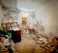 PREDAJ, 3 izbový byt na Štefánikovej ulici, Staré Mesto, Košice - Stará miestnosť s oprýskanými stenami, plná kôpok stavebného odpadu a nábytku.