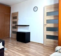 Na predaj 2 izbový byt, 47 m2, Bratislava, Nové Mesto, Piešťanská ul. - Obývacia izba v 2-izbovom byte s podlahou s dreveným dekorom a nábytkom.