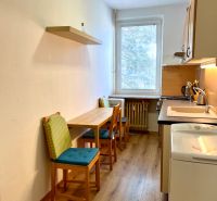 Na predaj 2 izbový byt, 47 m2, Bratislava, Nové Mesto, Piešťanská ul. - Kuchyňa s dvoma stoličkami a podlahou s dreveným dekorom v 2-izbovom byte.