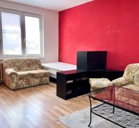 Na predaj 2 izbový byt, 47 m2, Bratislava, Nové Mesto, Piešťanská ul. - Obývacia izba v 2-izbovom byte s kreslami, stolíkom a podlahou s dreveným dekorom.