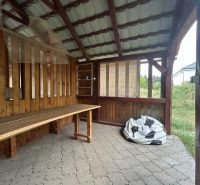 Na predaj 2 izbový byt 54 m2 po rekonštrukcii + záhrada, obec Telince - Drevený prístrešok v Telinciach a 2-izbový byt s kamennou podlahou v pozadí.