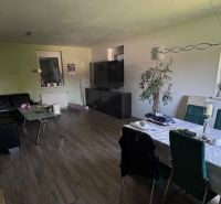 6-izb. rodinný dom, lokalita Nové Košariská, Dunajská Lužná - Obývacia izba rodinného domu s podlahou s dreveným dekorom a jedálenským stolom.