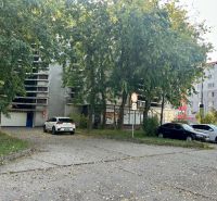 Nadštandardne veľká garáž na ul. Medveďovej, Petržalka - Parkovisko pri garážach na Medveďovej v Bratislave-Petržalke, s autami a stromami.