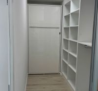 Novostavba 2,5-izb. bytu v NUPPU, garážové státie + vonkajšie státie - Minimalistický úložný priestor v 2-izbovom byte s podlahou s dreveným dekorom.