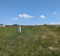 Stavebný pozemok 681 m2 v Štitároch  - Pozemky - bývanie na Zamoyského v Štitároch s trávnatým porastom, lampami a kopcom v pozadí.