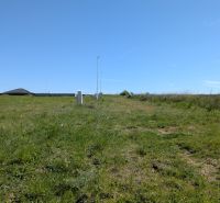 Stavebný pozemok v Štitároch 764 m2 s výhľadom na Nitru - Trávnaté pozemky určené pre bývanie v Štitároch pod modrou oblohou.