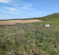 Stavebný pozemok v Štitároch 764 m2 s výhľadom na Nitru - Krajina v Štitároch s pozemkami pre bývanie, na ktorých vidno zelené lúky a pole.