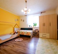 Priestranný 4 izbový rodinný dom po rekonštrukcii - Branč  - Detská izba v rodinnom dome s podlahou s dreveným dekorom a farebnými stenami.