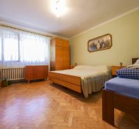 Rodinný dom s krásnym 18 á pozemkom ( stavebným) - Nové Sady  - Spálňa rodinného domu s podlahou s dreveným dekorom, lôžkami a skrinkou.