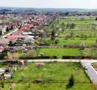 Nádherný pozemok pri lese - 687 m2 - Jelenec - Letecký pohľad na pozemky pre bývanie v Jelenci, obklopené zeleňou a domami.