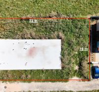 Základová doska na  575 m2 pozemku - Čeľadice  - Pozemky - bývanie v Čeľadiciach: zobrazuje oplotený trávnatý pozemok so stavbou.