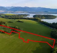 Liptovský Trnovec – 6.488 m2 POZEMOK na MOBILNÝ dom - Letecký pohľad na Zvláštne nehnuteľnosti v Liptovskom Trnovci s okolím a vodnou plochou.