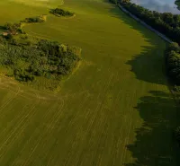 Liptovský Trnovec – 6.488 m2 POZEMOK na MOBILNÝ dom - Letecký pohľad na zelené pláne a lesy v okolí Liptovského Trnovca.