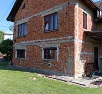Slnečný pozemok s rodinným domom v Ovčiarsku  - Rodinný dom v Ovčiarsku s neomietnutou tehlovou fasádou a zeleným trávnikom pre pozemky - bývanie.