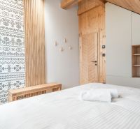 I Luxusné dvojpodlažné chalet pri Liptovskej Mare - Štýlová izba s dekorovanou stenou a podlahou s dreveným dekorom v hoteli.