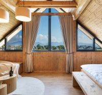 I Luxusné dvojpodlažné chalet pri Liptovskej Mare - Podkrovná izba v chate s panoramatickým výhľadom a podlahou s dreveným dekorom.
