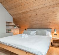 I Luxusné dvojpodlažné chalet pri Liptovskej Mare - Spálňa v Hotely a penzióny s podlahou s dreveným dekorom a šikmým dreveným stropom.