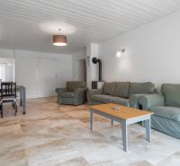 Stavebný pozemok 8 500 m² s podnikateľským potenciálom - Obývacia izba s pohovkami, konferenčným stolíkom a jedálenským kútom na podlahe s dreveným dekorom.