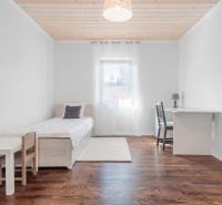 Stavebný pozemok 8 500 m² s podnikateľským potenciálom - Interiér s jedným lôžkom a stolom, podlaha s dreveným dekorom.