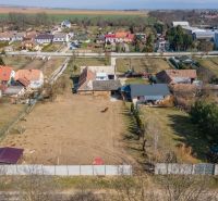 Stavebný pozemok 8 500 m² s podnikateľským potenciálom - Pozemky na bývanie v Dolnom Lopašove, obklopené domami, záhradami a výhľadom na okolie.