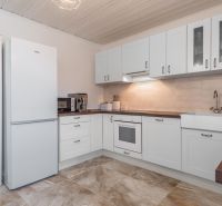 Stavebný pozemok 8 500 m² s podnikateľským potenciálom - Svetlá kuchyňa s bielymi skrinkami a poličkami, podlaha s dreveným dekorom.