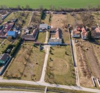 Stavebný pozemok 8 500 m² s podnikateľským potenciálom - Dedinský pohľad na pozemky v Dolnom Lopašove so záhradami a domami na bývanie.