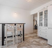 Stavebný pozemok 8 500 m² s podnikateľským potenciálom - Interiér s jedálenským stolom a stoličkami, vedľa biely kuchynský nábytok.