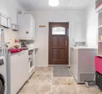 Stavebný pozemok 8 500 m² s podnikateľským potenciálom - Práčovňa s práčkou a úložným priestorom, podlaha s dreveným dekorom, biele steny.
