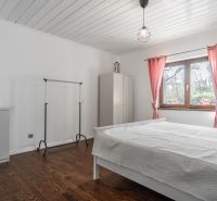 Stavebný pozemok 8 500 m² s podnikateľským potenciálom - Spálňa s ružovými závesmi, veľkým oknom a podlahou s dreveným dekorom.