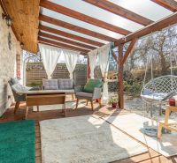Stavebný pozemok 8 500 m² s podnikateľským potenciálom - Zastrešená terasa s ratanovým nábytkom na pozemku pre bývanie v Dolnom Lopašove.