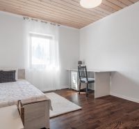 Stavebný pozemok 8 500 m² s podnikateľským potenciálom - Spálňa s posteľou, stolíkom a podlahou s dreveným dekorom. Pozemky - bývanie.