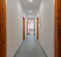 I PREDAJ – FUNGUJÚCA PEKÁREŇ A POTRAVINY V TRNAVE - Úzka chodba s dverami so sklom, vedúca do miestnosti s nábytkom v priestoroch.