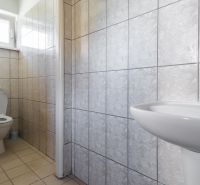 I PREDAJ – FUNGUJÚCA PEKÁREŇ A POTRAVINY V TRNAVE - Toaleta so svetlými dlaždicami a bielym sanitárnym vybavením vo výrobných priestoroch.