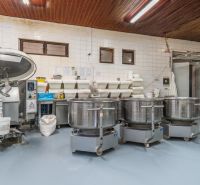 I PREDAJ – FUNGUJÚCA PEKÁREŇ A POTRAVINY V TRNAVE - Výrobné priestory s mixérmi, nádobami a podlahou s dreveným dekorom.
