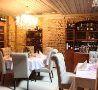 ZNÍŽENÁ CENA! I Predaj komerčného priestoru na ul. Obchodna - Reštauračné obchodné priestory s kamennými stenami a lustrom, elegantne prestreté stoly.