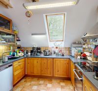 Rodinný dom 240 m², 3 bytové jednotky, veľký pozemok, Lamač - Kuchyňa v rodinnom dome so strešným oknom, drevenými skrinkami a nerezovými spotrebičmi.