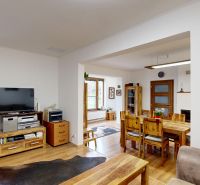 Rodinný dom 240 m², 3 bytové jednotky, veľký pozemok, Lamač - Obývačka s TV, dreveným nábytkom a podlahou s dreveným dekorom v rodinnom dome.