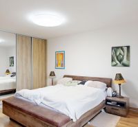 Rodinný dom 240 m², 3 bytové jednotky, veľký pozemok, Lamač - Spálňa v rodinnom dome s posteľou, vstavanou skriňou a podlahou s dreveným dekorom.