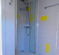 Rodinný dom s veľkou záhradou - Ružinov  - Sprchovací kút s viacfarebnou stenou a podlahou s dreveným dekorom v rodinnom dome.
